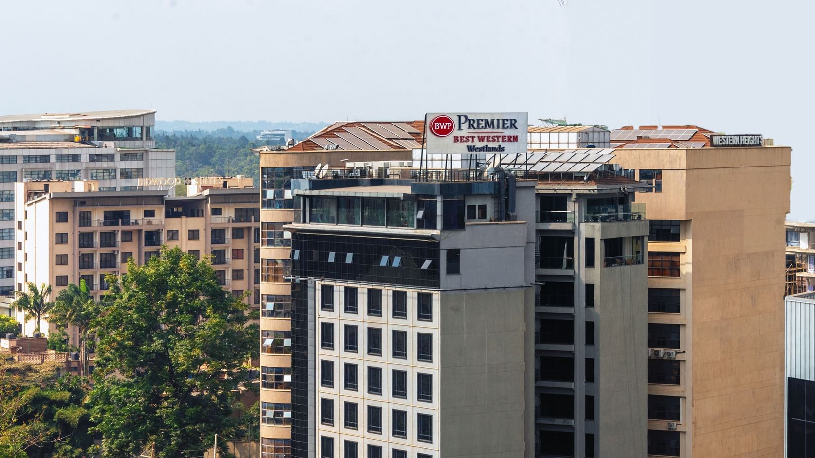 Exterior view of Best Western Premier Westlands with city buildings and trees nearby.