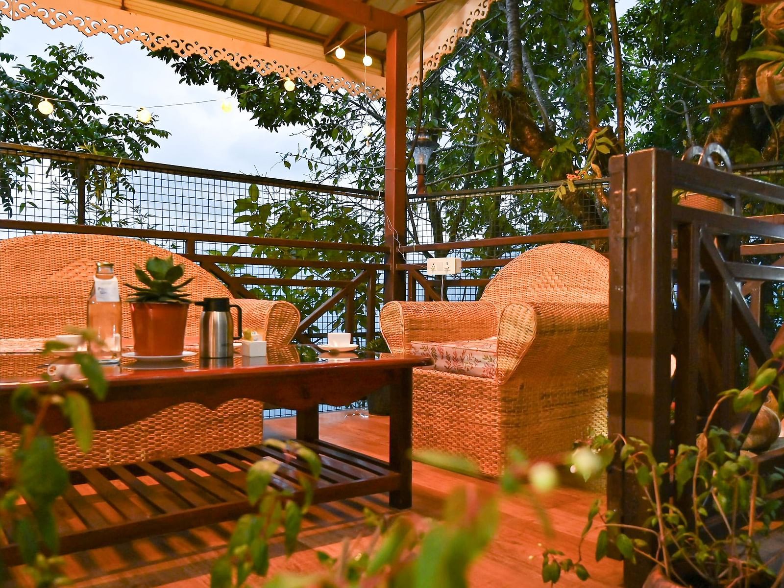 a beautiful garden at Yashshree Karbari Resort & Spa, Yangang during the evening with a cream coloured couch set and a centre table