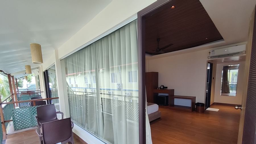 Spacious bedroom with a king-sized bed, simple décor, and wooden ceiling accents