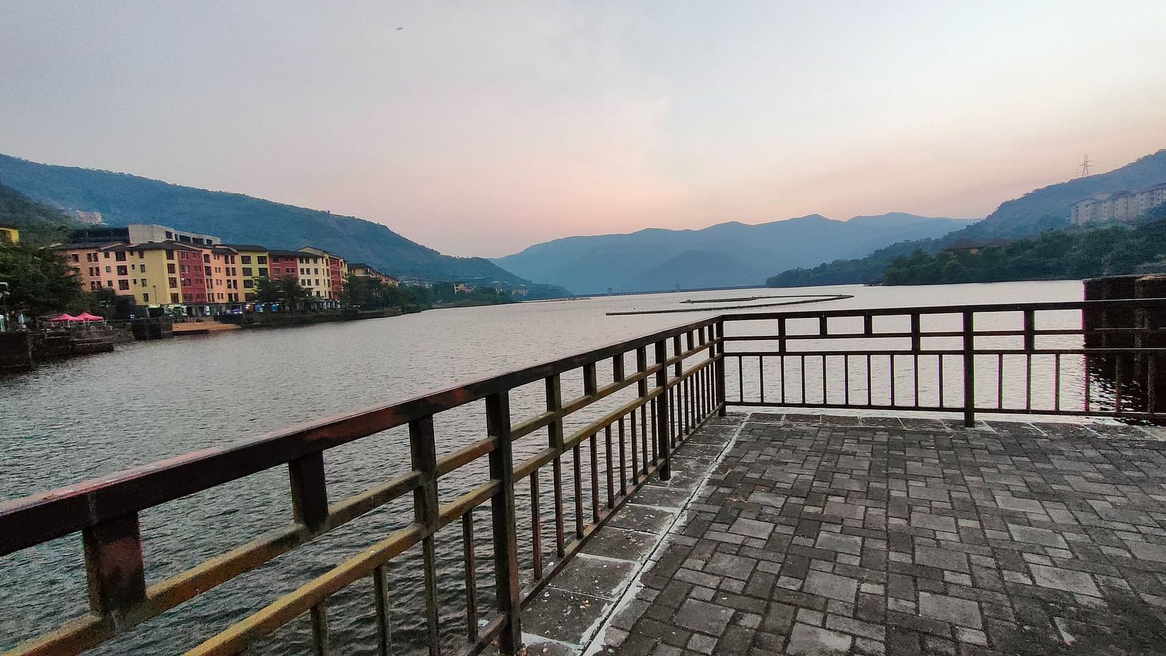 The lake running along the vibrant buildings of Lavasa featuring magnificent outlines of mountains in the background