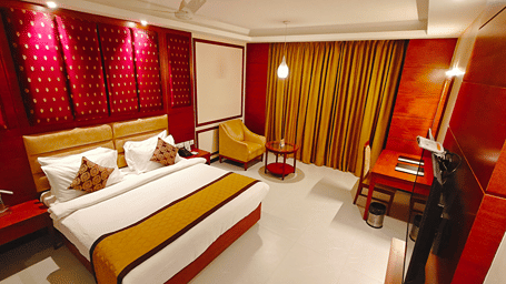 A room with a large bed, sheets, pillows, and curtains. | MM Legacy, Kanchipuram