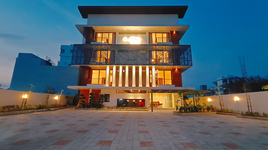 The illuminated evening exterior of Bliss Giriya By Bergamont Tiruvannamalai with landscaped grounds and a clear sky.