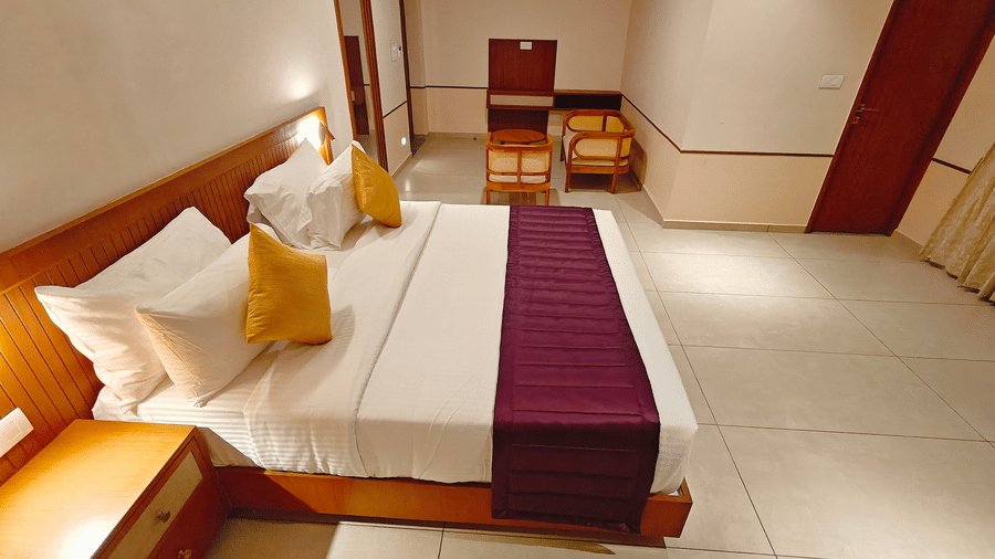 A spacious room interior at Bliss Giriya By Bergamont Tiruvannamalai with a double bed and angled ceiling.