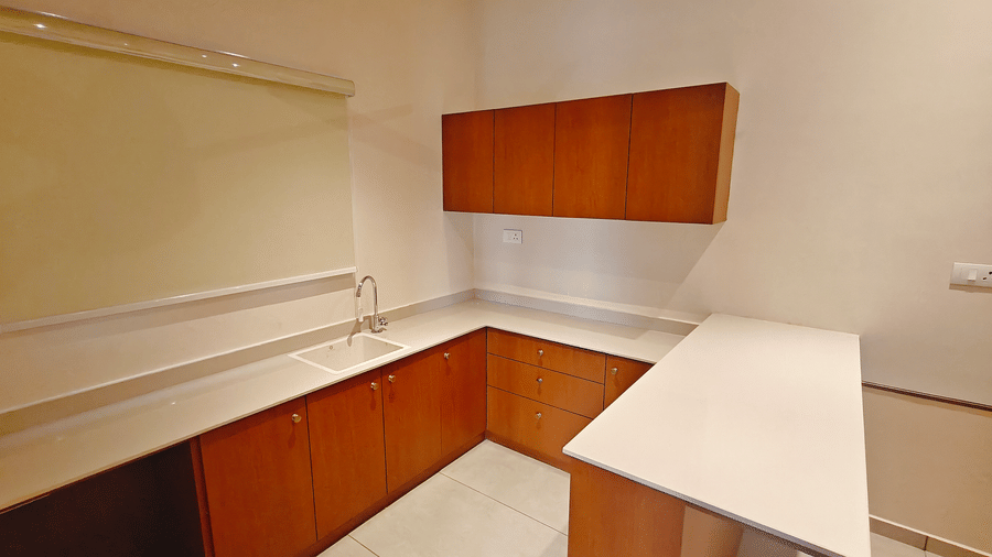 A built-in wooden kitchenette and storage counter in a room at Bliss Giriya By Bergamont Tiruvannamalai.