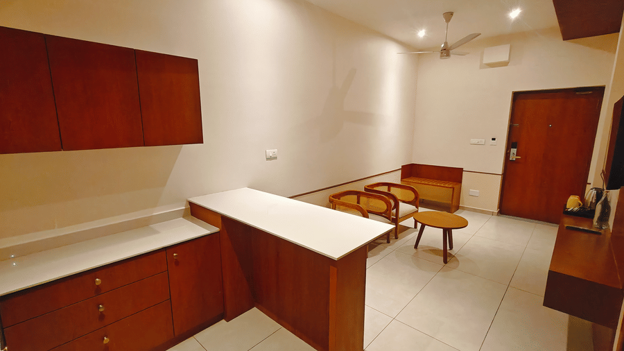 A room at Bliss Giriya By Bergamont Tiruvannamalai with a built-in wooden work counter and wardrobe storage unit.