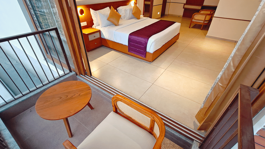 An overhead view of a room at Bliss Giriya By Bergamont Tiruvannamalai showing a double bed and balcony seating area.