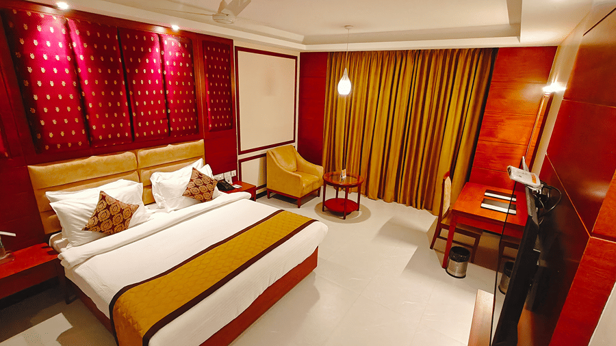 A room with a large bed, sheets, pillows, and curtains. | MM Legacy, Kanchipuram