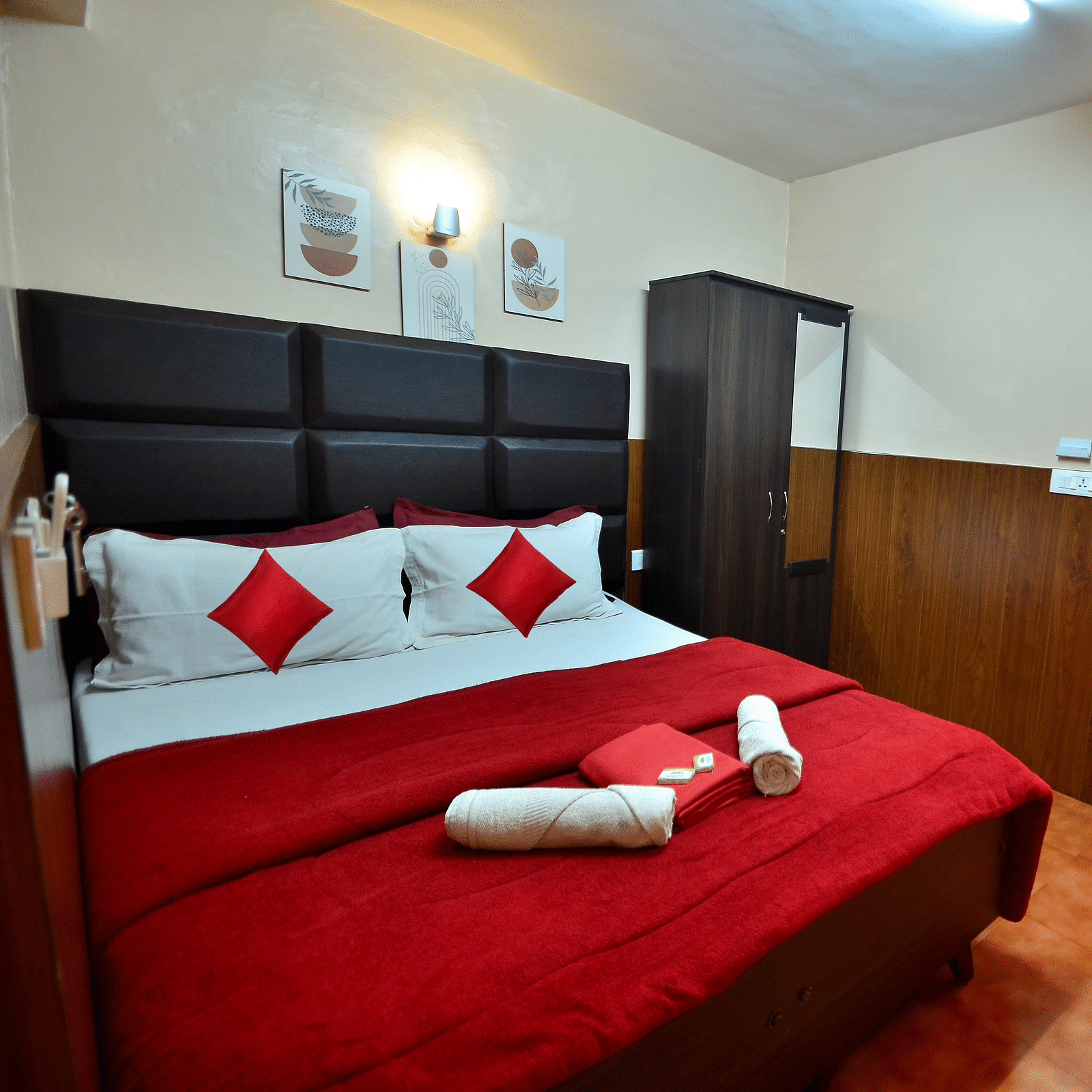 Image of a room with a double bed and a wardrobe on the side at BN Tourist Home, Ooty