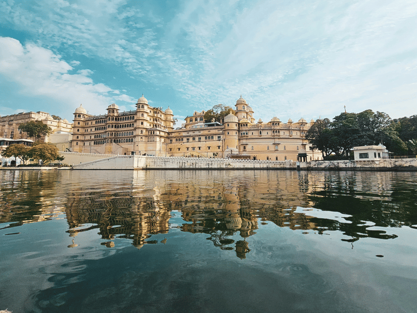 Udaipur City Palace with its reflection shimmering on the water.