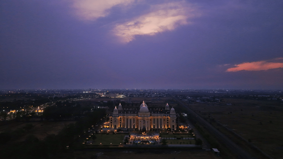 Aerial evening view of Hotel Hukam's Lalit Mahal beautifully lit under a twilight sky with surrounding landscape visible.