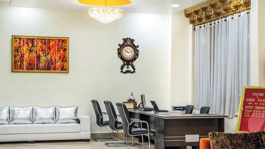 A lobby area at Hotel Singge Palace, featuring a sofa, a table, and chairs.