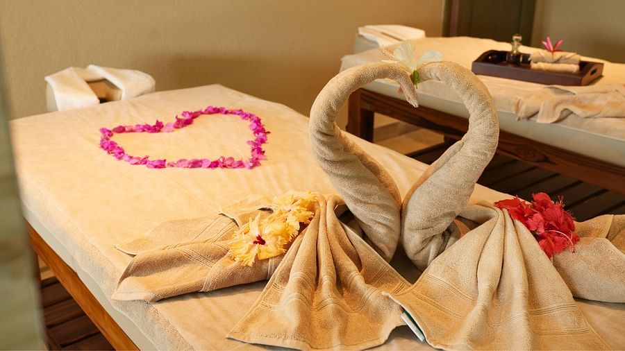 The heart-shaped towel arrangement with rose petals clearly aims to evoke romance and intimacy.