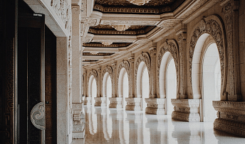 A hallway with arched doorways and carvings. 