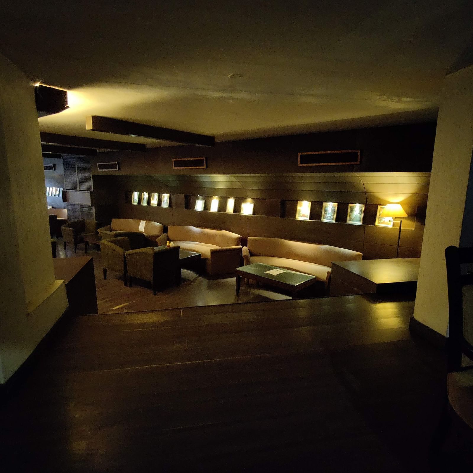 A dimly lit indoor seating area at 24 Karats bar - Hotel Gold, Panipat