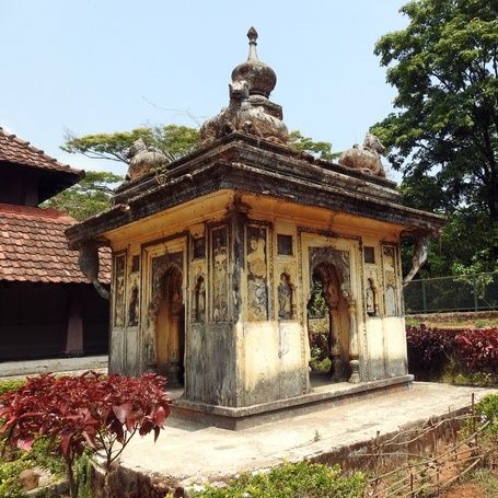 Ancient Nalknad Palace with a dome, surrounded by nature.