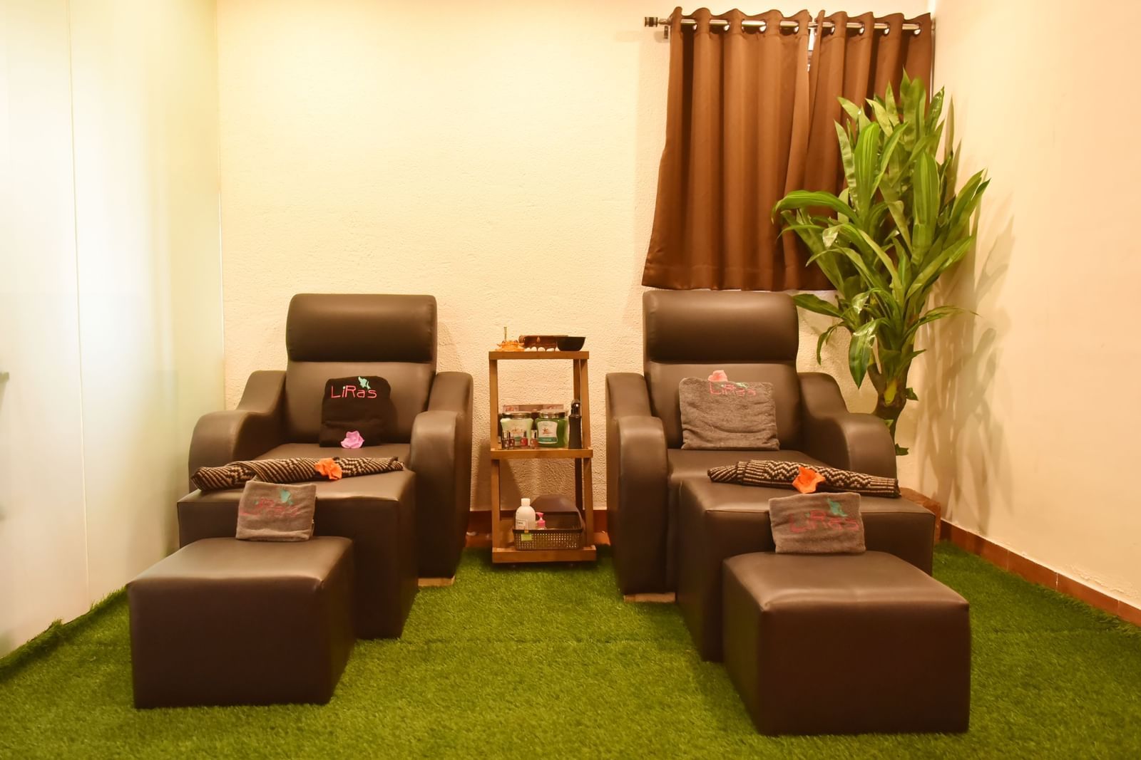 Two comfortable massage chairs with foot rests in a relaxing spa setting at Forest Escape, with plants and soft lighting.