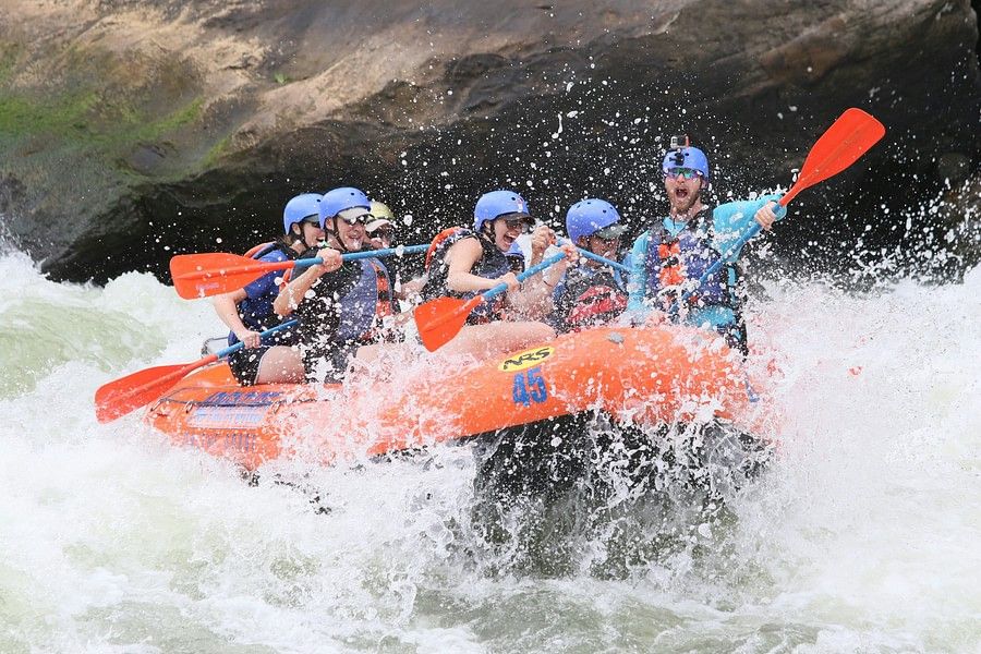 Close-up of the same group of rafters, splashing through a particularly rough section of the river, emphasizing the excitement and challenge of the activity.
