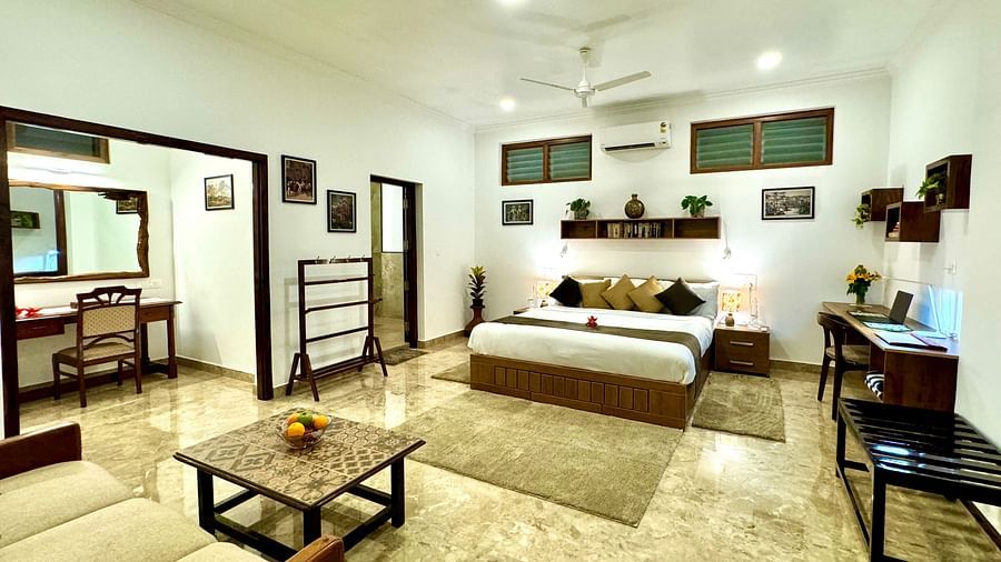 Well-lit bedroom with a double bed, seating area, and various decorative items - BluSalzz Collection - Tranquil Resort, Wayanad