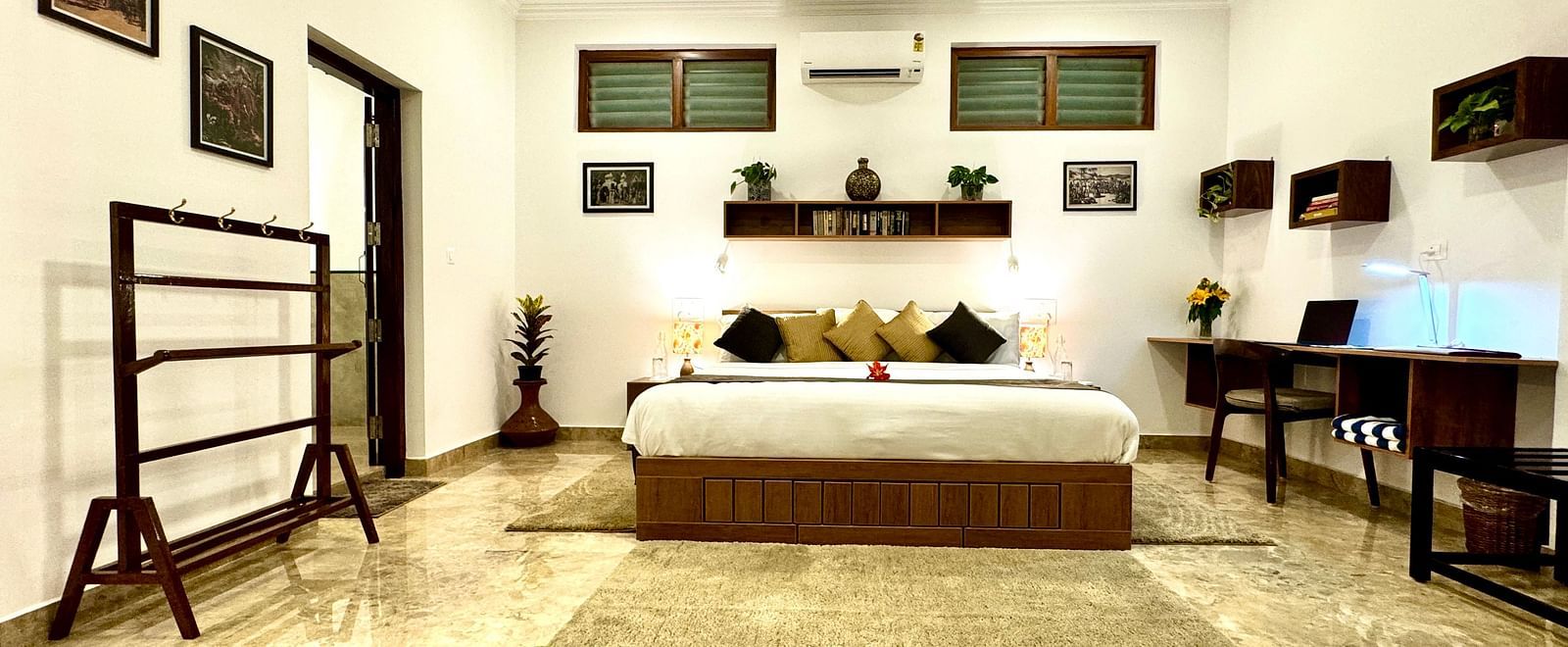 Comfortable bedroom with a double bed, wooden furniture, and decorative wall hangings - BluSalzz Collection - Tranquil Resort, Wayanad