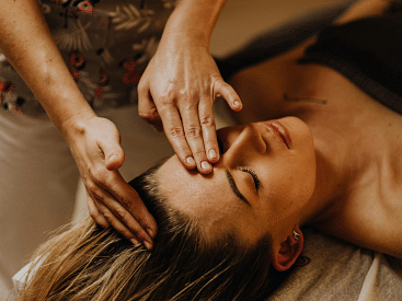 Close-up of a woman receiving a head massage.