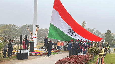 An Indian flag being hoisted during daytime with people gathered around - Karma Lakelands.