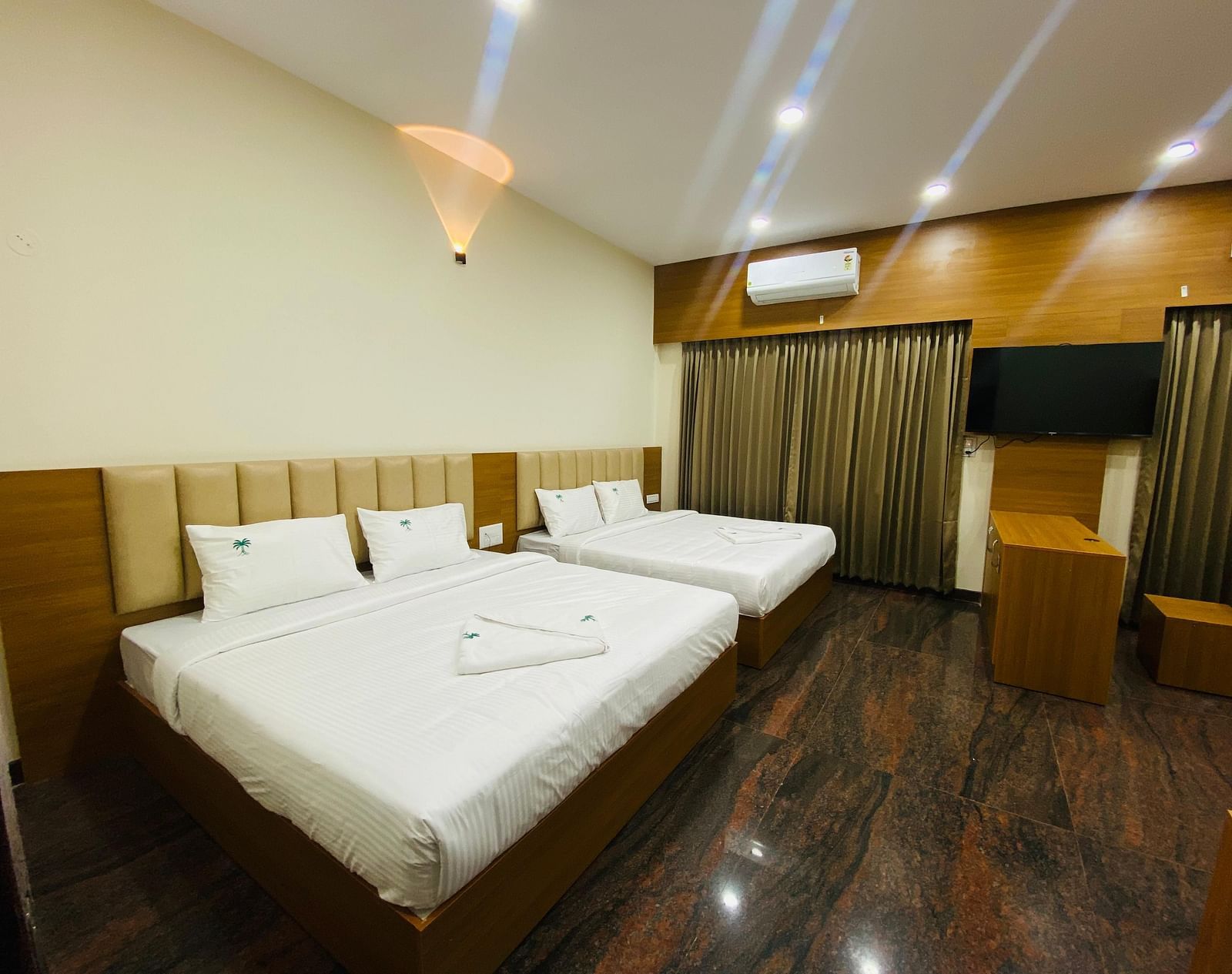 Elegant king-size bedroom with rich wooden flooring and soft lighting at Hotel Sahara Tree.