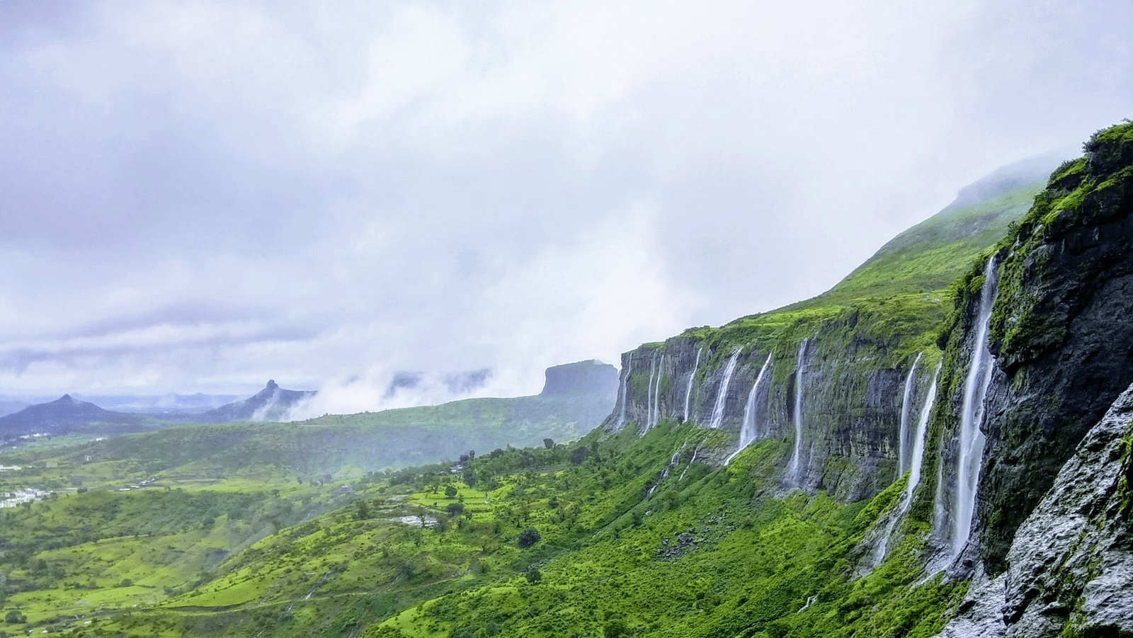 an image of a  stunning view of the waterfall flowing from the mountains