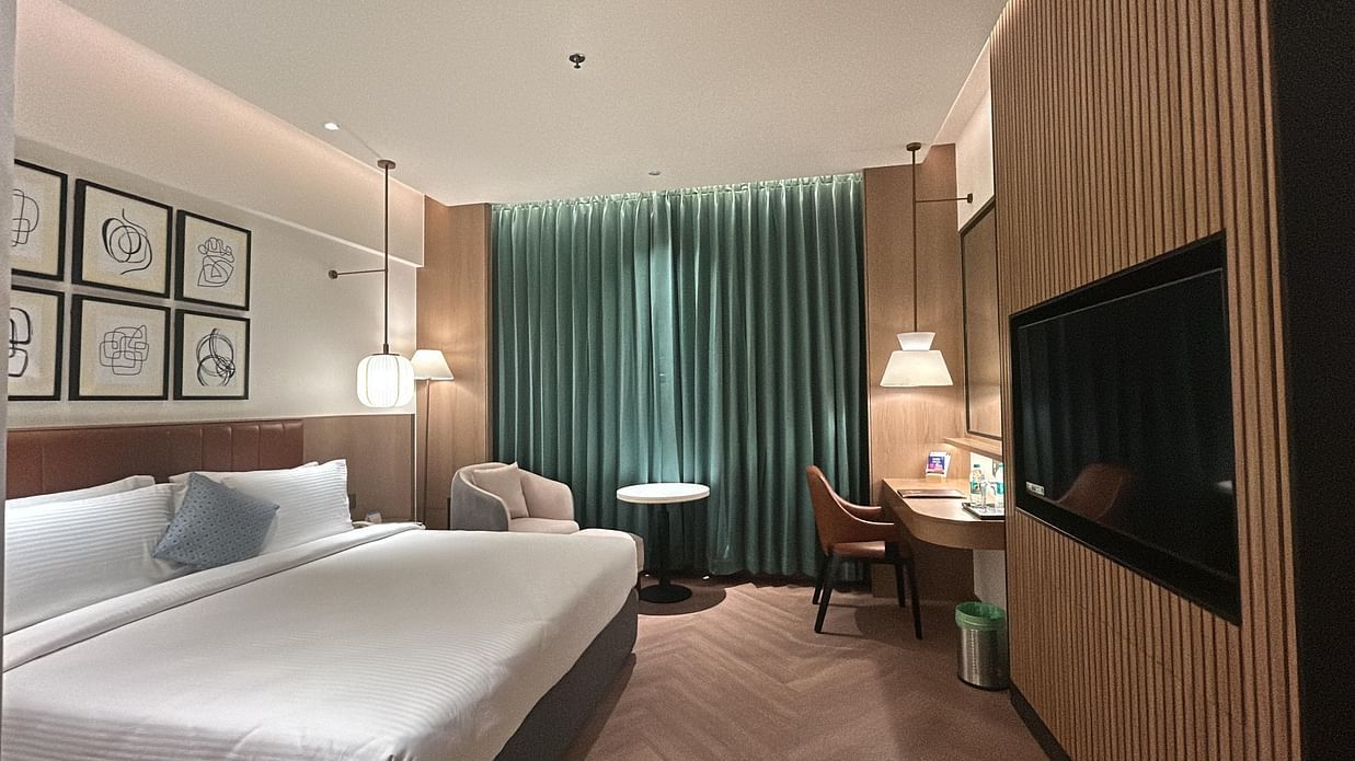 Well-lit Deluxe Room with seating area and television at Dolphin Hotel