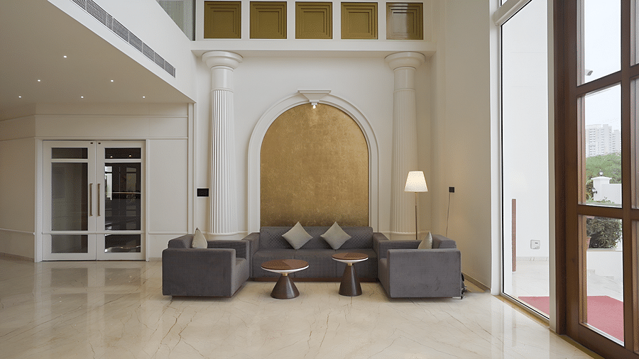 A luxurious hotel lounge area at Pride Resort, Rajkot featuring a plush seating, elegant lighting, and a large decorative arch, showcasing sophisticated interior design.