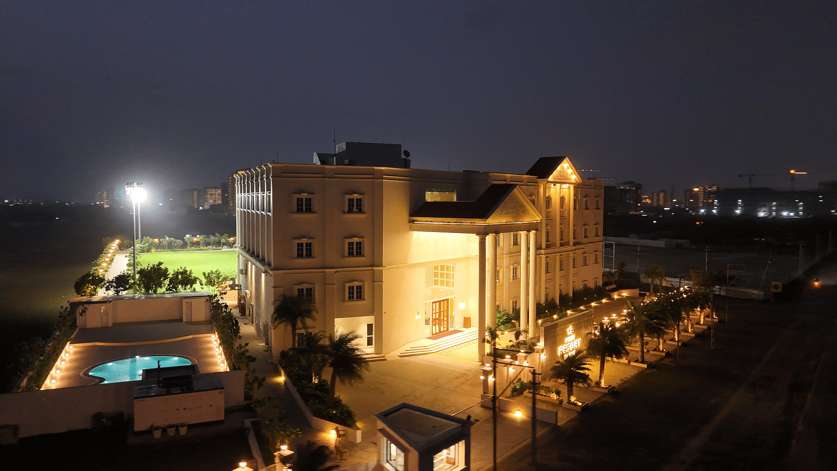 Side view shot of the resort taken during late evening featuring a swimming pool in the side - Pride Resort, Rajkot