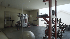 A modern hotel gym at Prider Resort, Rajkot filled with various exercise machines, including treadmills and weights, providing a comprehensive workout space