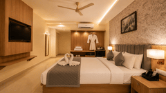 Premium Room at Tulip Inn, Hoodi Whitefield, Bengaluru, with a double bed, towel swans, wall-mounted television, and a hanging bathrobe.