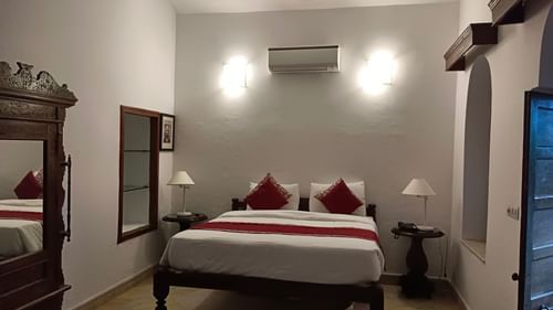 An overview of the Maharaja Raninder Singh room with a king size bed and an AC mounted on the wall - The Baradari palace