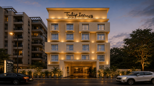 Exterior view of Tulip Inn, Hoodi Whitefield, Bengaluru at night, with building illumination, windows, trees, and parked cars.