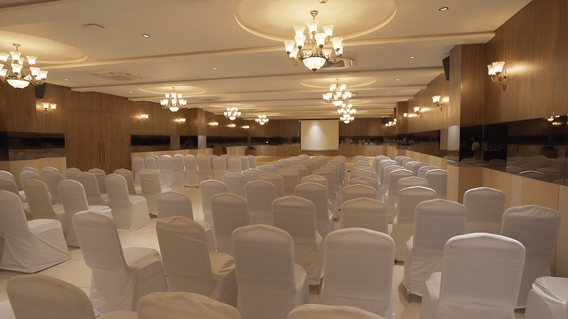 Overview shot of a Imperial hall with central air-conditioning with well arranged seating area - Pride Resort, Rajkot
