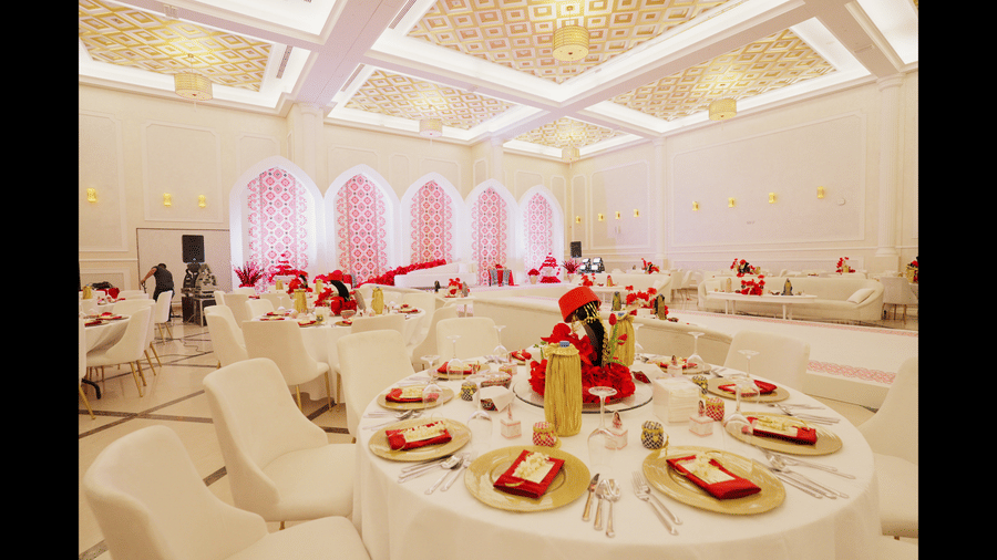 An elegantly decorated banquet hall at La Maison, Doha, with round tables set for a formal event.