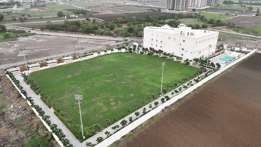 Overview of an expansive lawn with tall halogen lights put up in the perimeter - Pride Resort, Rajkot