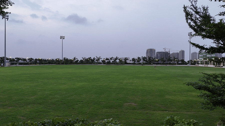 An expansive lawn with tall halogen lights put up in the perimeter - Pride Resort, Rajkot