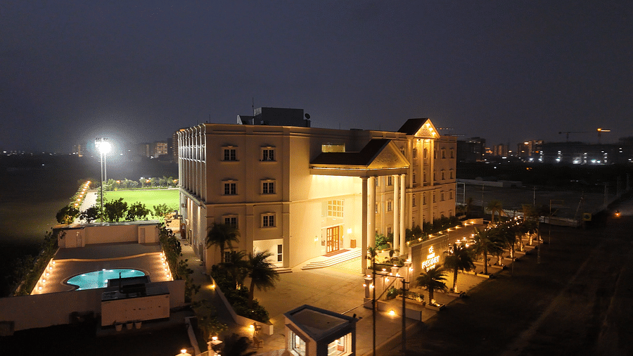 Side view shot of the resort taken during late evening featuring a swimming pool in the side - Pride Resort, Rajkot