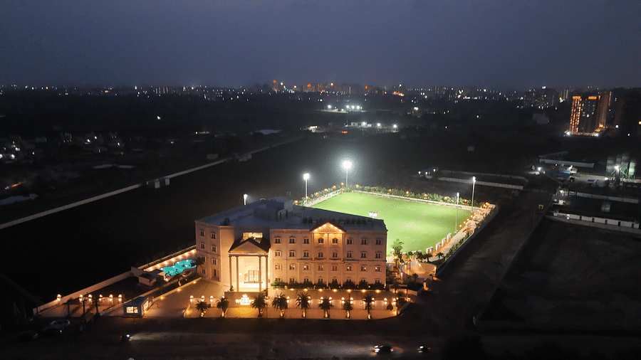 A bird's eye view of the resort taken during a late evening featuring a huge lawn behind the building - Pride Resort, Rajkot