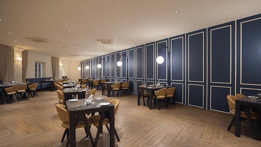 Full view shot of the restaurant at Pride Resort, Rajkot with navy blue coloured walls giving an elegant look