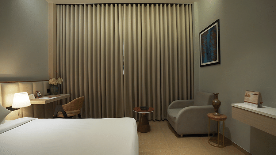 Overview shot of Premium Room featuring a comfortable double bed with pillows and cushions arranged over it - Pride Resort, Rajkot