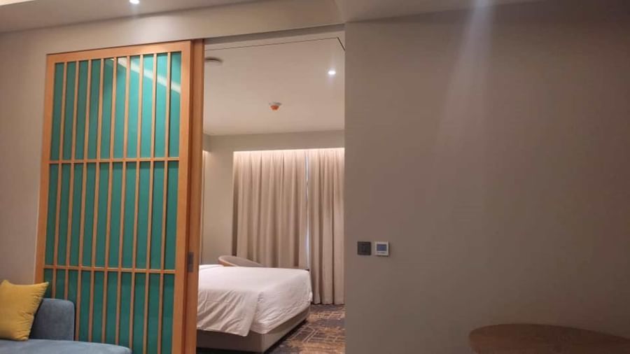 A Hargeisa suite featuring a living area and a bedroom, separated by wooden door - Serene Sarovar Premiere Hargeisa