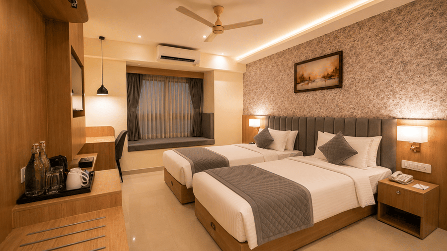 Guest Room at Tulip Inn, Hoodi Whitefield, Bengaluru, with 2 single beds, bedside tables, lamps, wall art, and window seating.