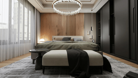 Wide bed with olive green bedding, a large circular chandelier, dark wardrobes, and a grey bench at the foot of the bed.