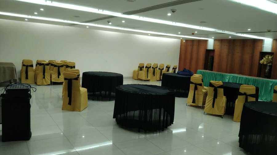 Banquet hall arranged with black and gold chair covers for an event at Pipul Utkal Continental, Jharsuguda.