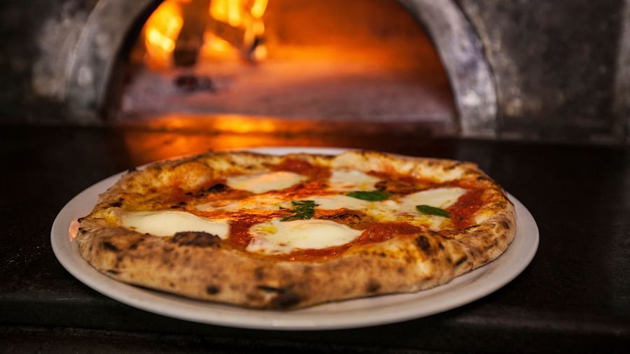  A delicious-looking pizza served on a plate - Rhythm Lonavala