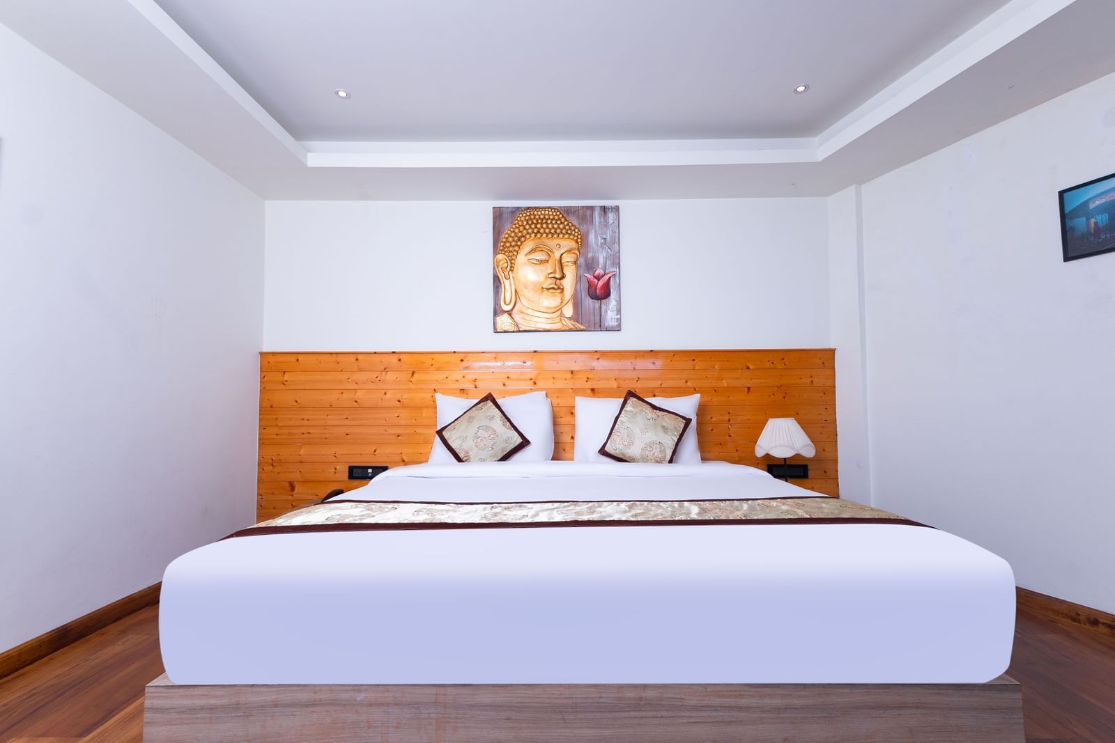 Spacious guest room at Sumitel Premier Inn, Siliguri, with a large comfortable bed, modern décor, and soft lighting creating a relaxing atmosphere.