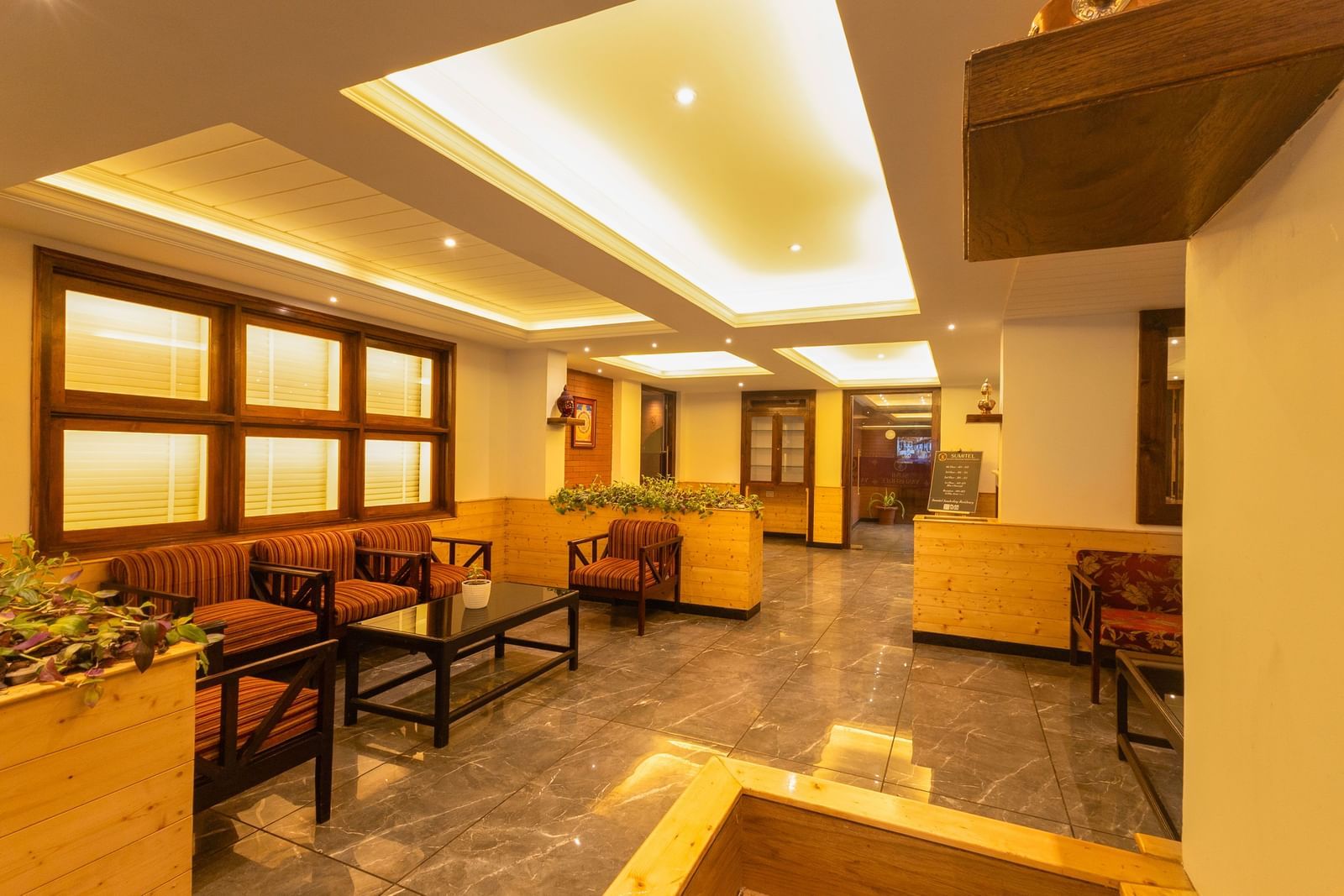 Elegant lobby seating with sofas and artwork at Sumitel Premier Inn, Siliguri.