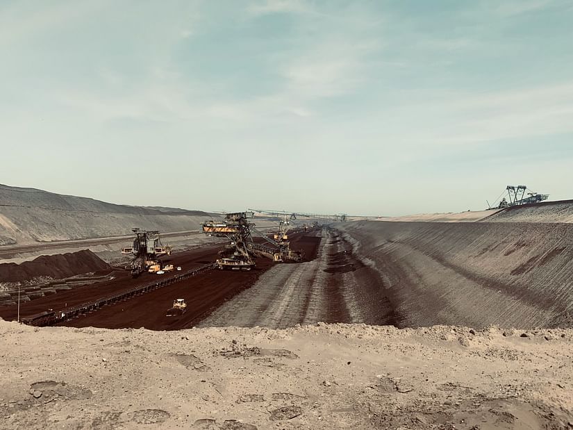 Large vehicles in a field with elevated surface on either sides.